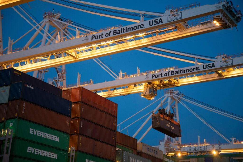 pexels photo 1117211 1117211 Illuminated cargo cranes at the Port of Baltimore with stacked containers at dusk.