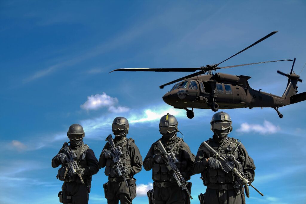 pexels photo 20258 Special forces soldiers in tactical gear with helicopter overhead under a blue sky.
